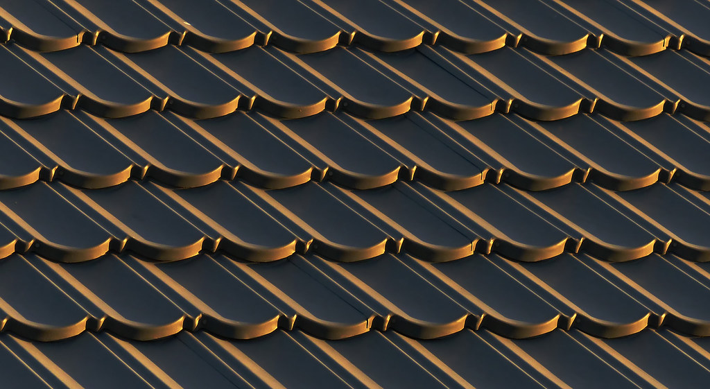 Close pattern of dark and gold roof tiles (representative photo)
